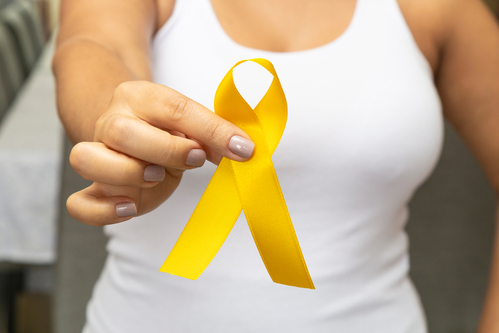 Young,Woman,,With,Pink,T-shirt,,Holding,Yellow,Ribbon,,Preventing,Aids.